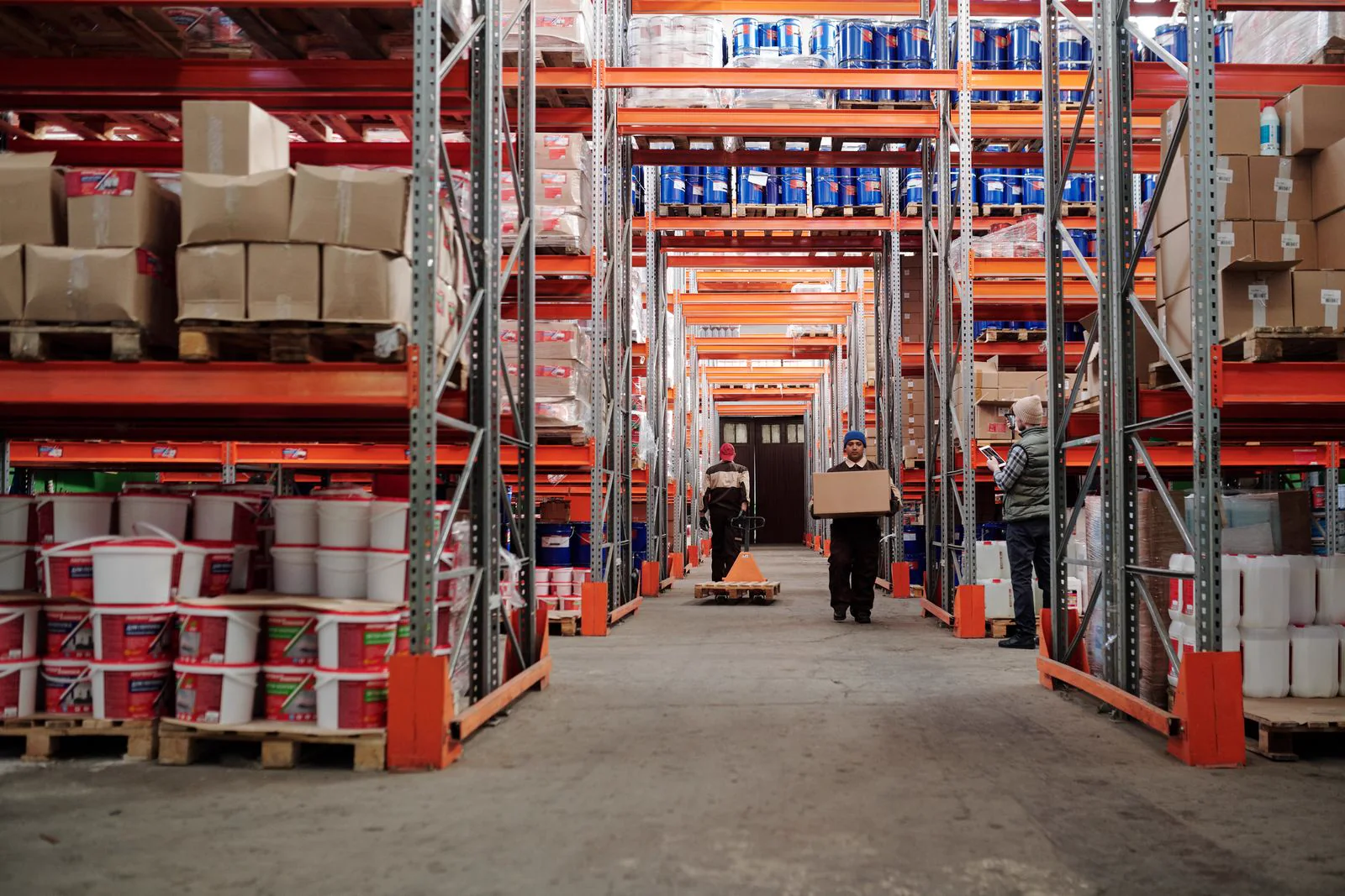 Equipo trabajando entre racks y pallets de un centro de distribución